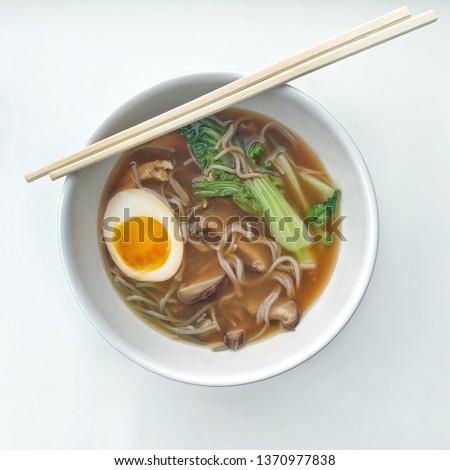 Traditional japanese ramen bowl with miso tare, chicken, bok choy and soft boiled egg Ajitsuke Tamago. Top view in white background. Asian cuisine, cooking at home. Gluten free, buckwheat ramen. 