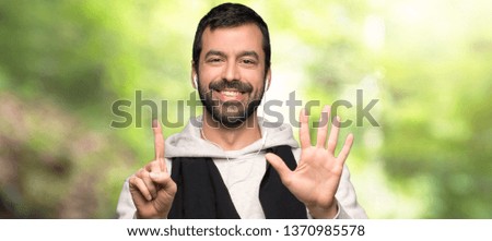 Sport man counting six with fingers in a park