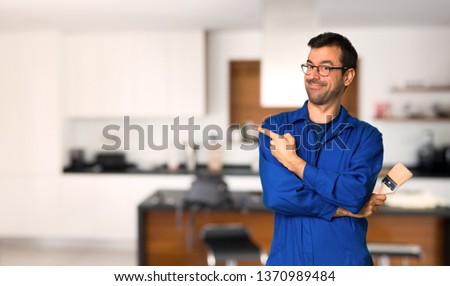 Painter man pointing to the side to present a product at home