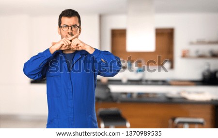 Painter man showing a sign of silence gesture at home