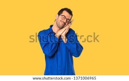 Painter man making sleep gesture in dorable expression on isolated yellow background