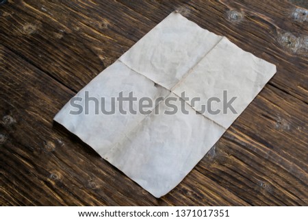 Blank sheet of old paper on a wooden table.