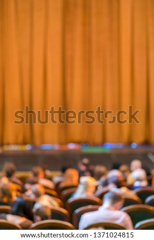 Audience in Theater. closed stage curtain in a theater. blurry. vertical photo