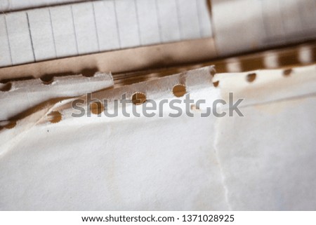 Old paper with punched holes. Wrinkled and torn paper edges.