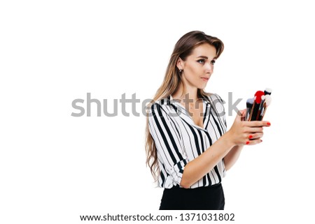 make-up artist girl on a white background holding a white brush and one large red