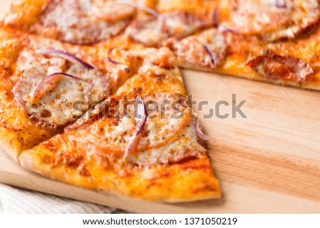 food, culinary and eating concept - close up of sliced homemade pizza on wooden table