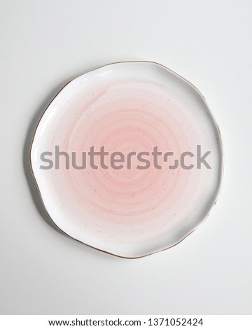 New luxury cutlery view from above on a isolated white background. Top view. Porcelain pink saucer with gold ring. Trendy Coral plate tones. Flat lay view. Royalty-Free Stock Photo #1371052424