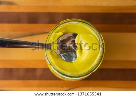 spoon in jar of dijon mustard sauce