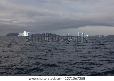 Large icebergs drifting in the distance offshore of Greenland