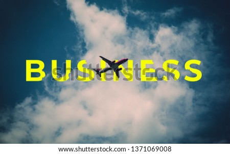 A picture of word business with an airplane in the air.