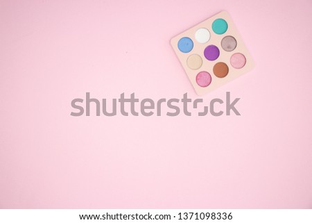 One colorful eye shadow palette on the pink background 
