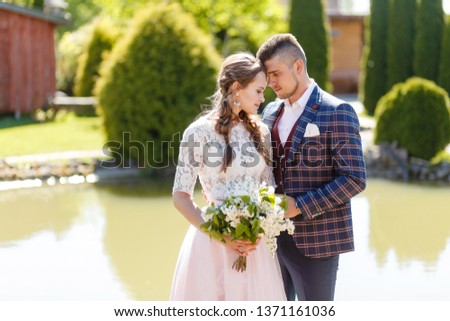 Bride and groom hugging on a sunny day in the park