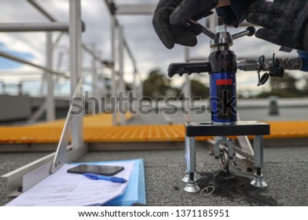 Pull testing strength of roof anchor point prior to used abseiling Sydney CBD, Australia  