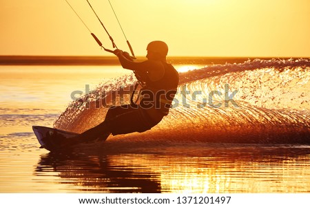 Silhouette of a kitesurfer during a trick on a board with water splashes,Ukraine, Genichesk
 Royalty-Free Stock Photo #1371201497