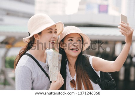 Asian tourists take a self photo with smartphone