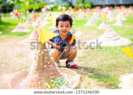 Boy make the Sand Pagodas with colorful flags in Songkran Festival Thailand, Thai temple, Songkran festival in thailand