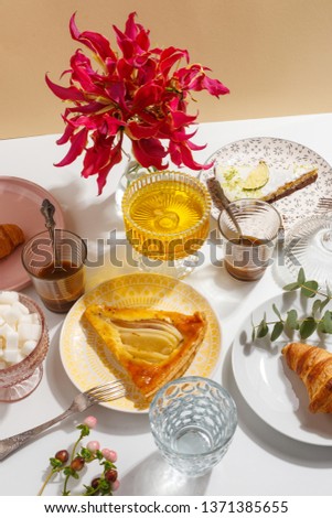 Lemon and pear pie on color plates on the table with coffee, sugar and honey. Table setting.