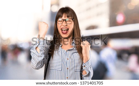 Woman with glasses celebrating a victory at outdoors