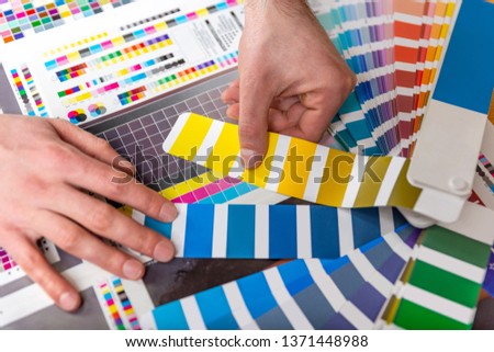 Graphic designer choose colors from the color palette sample for design. Designer graphic creativity work concept. Press color management - print production.