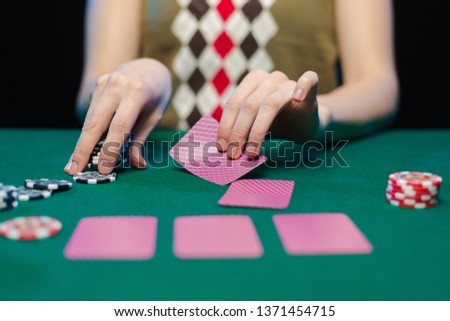 Female hands lay out playing cards and chips in a casino on a green table