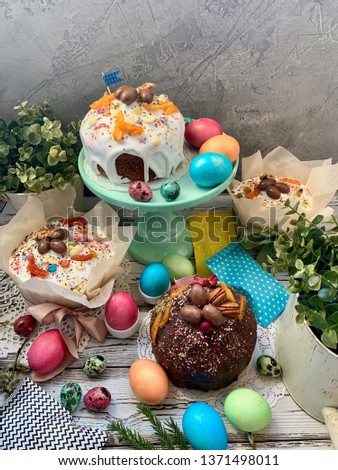 	Sweet, Easter table, Easter cupcakes in icing, with multi-colored sprinkles, painted chicken and quail eggs.