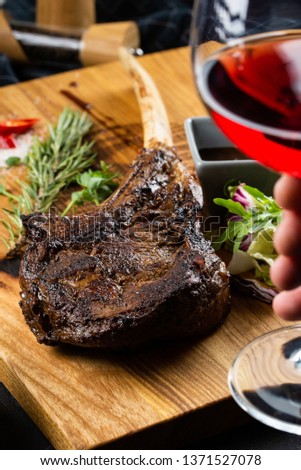 Roasted meat on bone served on wooden board– stock image