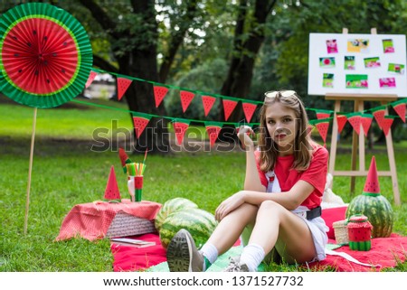 Nice teen girl having fun watermelon party In the park. Excellent sunny weather. Summer concept. Watermelon party, picnic, day.