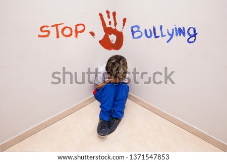 CHILD SUFFERING BULLYING DIGITAL, text over picture saying STOP BULLYING. Concept of child abuse or problems.