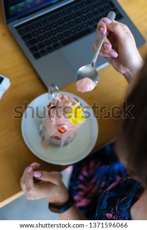 young female working on a laptop, healthy breakfast with chia seeds and juice. Freelance laptop smartphone breakfast. using smartphone and laptop touch screen display