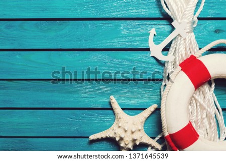Decorative Lifebuoy and anchor on blue wooden planks background