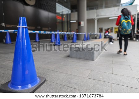 Blue and white witches hat cone traffic warning sign barrier applying on busy street at Parramatta on pedestrian footpath, road under construction in Parramatta city, Sydney, Australia 
