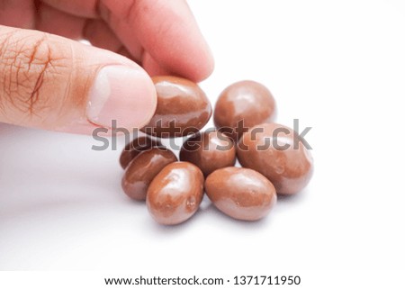 almond, hazelnut and raisin coated with milk chocolate isolated on white background