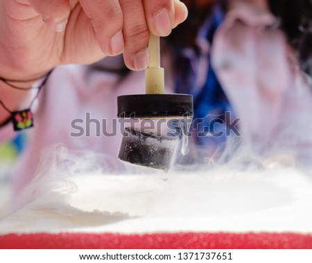 Demonstration of Quantum Magnetic Levitation and Suspension Effect. A splash of liquid nitrogen cools a ceramic superconductor forcing it to float in air below a magnet Royalty-Free Stock Photo #1371737651