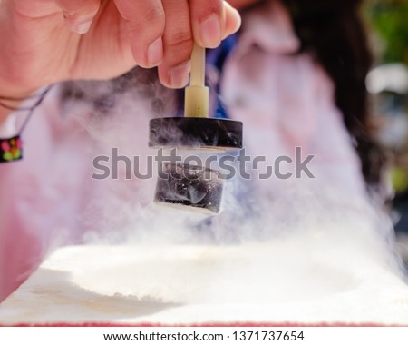 Demonstration of Quantum Magnetic Levitation and Suspension Effect. A splash of liquid nitrogen cools a ceramic superconductor forcing it to float in air below a magnet Royalty-Free Stock Photo #1371737654