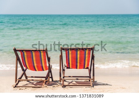 Two chairs on the beach near sea.Summer and vacation concept background