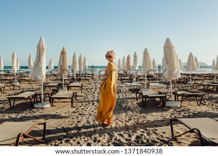 Woman Look Back at Parasol Lounger on Sand Beach. Girl Travel Vacation Sea Sandy Bay in Italy Resort. Sunrise Tropical Empty Shore Landscape Photo with Copy Space. Coast Sandy Seaside