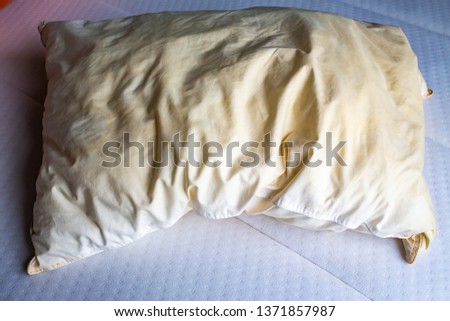 Dirty stained pillow on new white bed, Close up shot, Selective focus, Bedroom cleaning concept