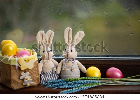 Happy Easter Background with colorful eggs in basket and hare. Table decorating for holiday.
