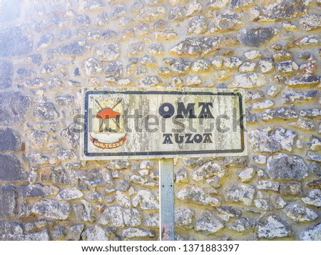 sign at the entrance to the village of Oma. Because of the inclemency it is seen that this dirty