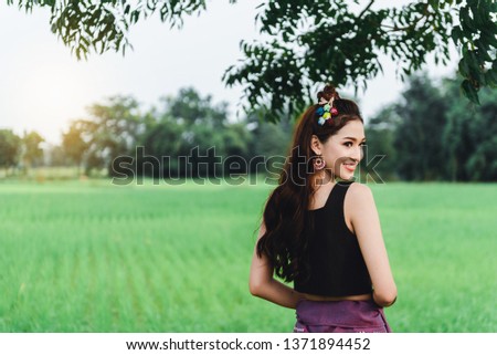 Beautiful Asian woman in local dress standing and enjoy natural on bamboo bridge in rice field 