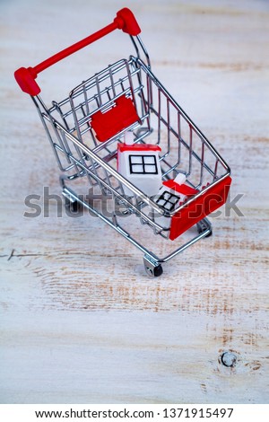 Shopping cart and houses. Concept: buying, selling and renting real estate.