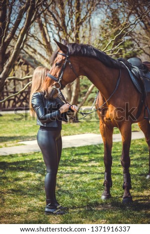 Rider elegant woman talking to her horse. Portrait of horse pure breed with woman. Equestrian horse with rider playpen for horses background