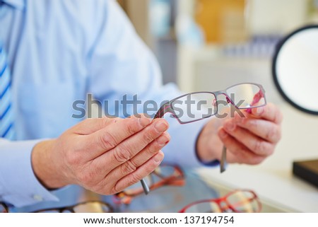 Hands holding new glasses at the optician Royalty-Free Stock Photo #137194754