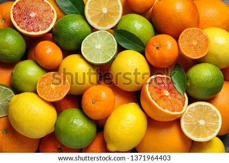 Many different citrus fruits as background, top view Royalty-Free Stock Photo #1371964403