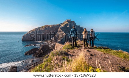 A group of two girls and a boy looking at the beautiful Gaztelugatxe