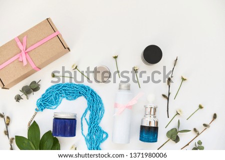 Cosmetics background with green branches and flowers, advertising poster for your store and stock, top view, copy space for text