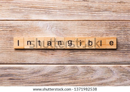 intangible word written on wood block. intangible text on wooden table for your desing, concept. Royalty-Free Stock Photo #1371982538