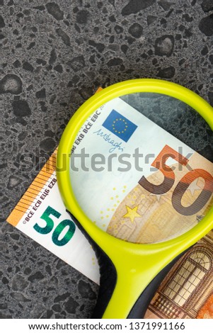 magnifying glass and money euro isolated on stone background, bancnots