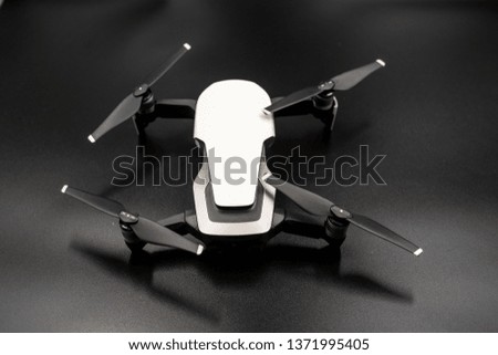 Drone - Flying in the dark, on black background. Closeup on dark. Portable drones, View on the drones gimbal and camera.