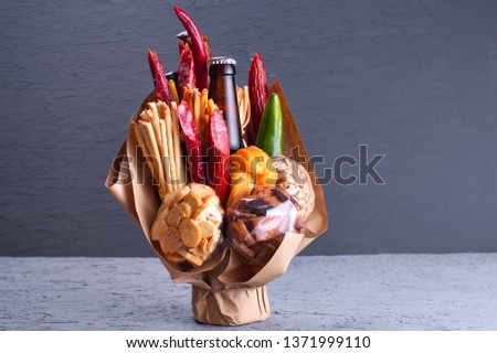 gift to a man: a tasty snack, a composition from a bottle of beer, hunting sausages, pepper, nuts, crackers, Sulguni cheese. Copy space